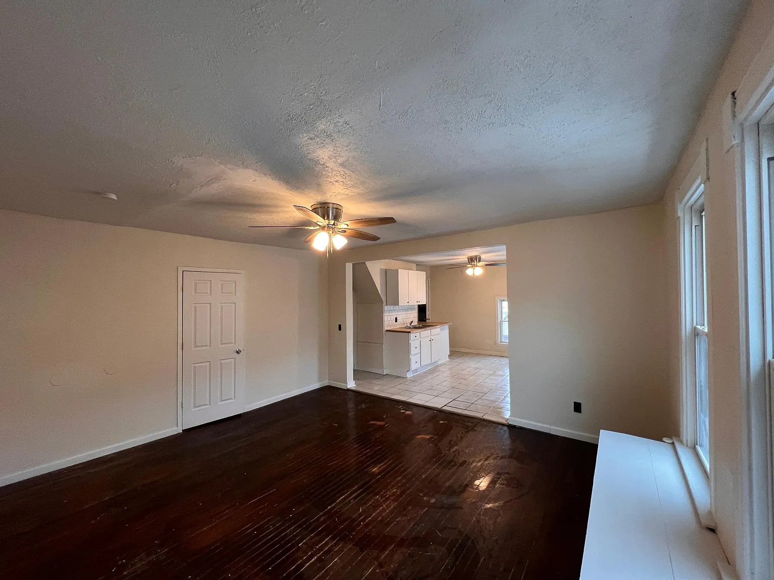 Living room facing second bedroom and kitchen