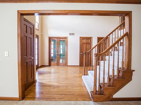 View of the grand entry foyer with the formal study with french doors in the backdrop