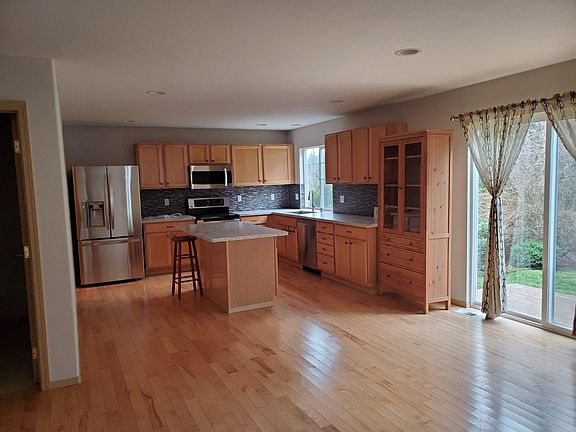 Kitchen with a walk-in pantry and quartz counters. Sliding doors lead to a deck in the large back yard.