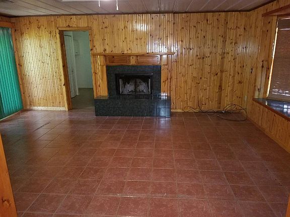 Living/den with wood burning firplace and paneled walls