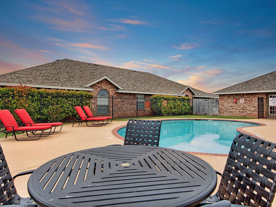 A pool surrounded by lounge chairs and tables for resident use