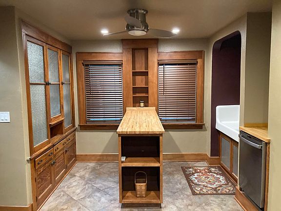 Big kitchen with stainless dishwasher, butcher block island & tile floor