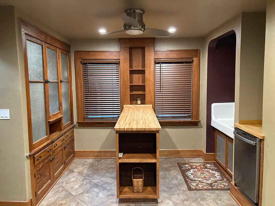 Big kitchen with stainless dishwasher, butcher block island & tile floor