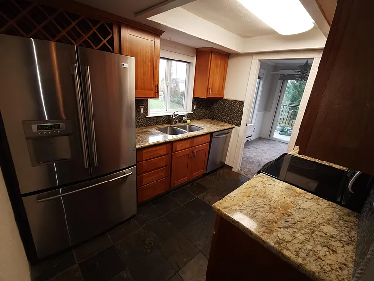 New kitchen, with marble countertop, slate floors, and new stainless steel appliances.