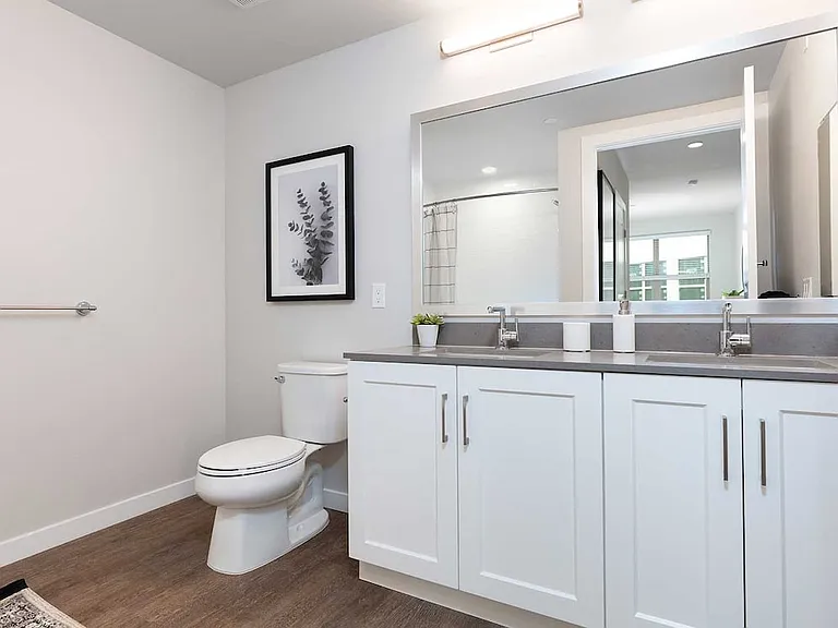 Upgrade Collection bath with white cabinetry, grey quartz countertop, and hard surface flooring