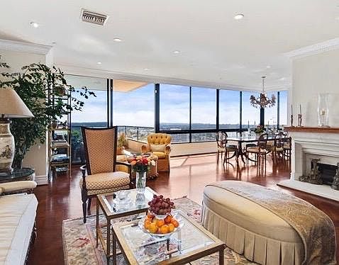 The living and dining room are dripping with light and look out towards the city and ocean