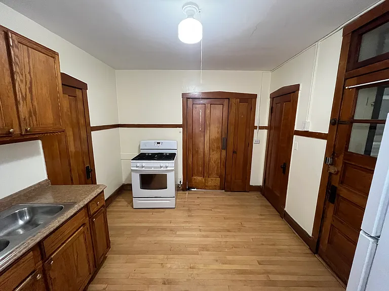 Kitchen with refinished cabinets, includes refrigerator, stove. Doors next to stove is a butler door, built in spice closet, Large walk in pantry, back door to rear staircase.
