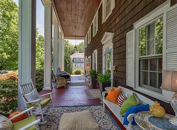 The colonnaded porch runs across the entire front of the home and provides an exceptionally special outdoor living space