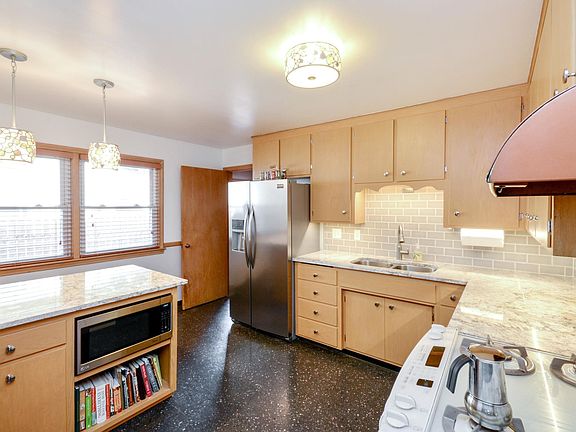 Eat in kitchen with granite counters and subway tile backsplash.