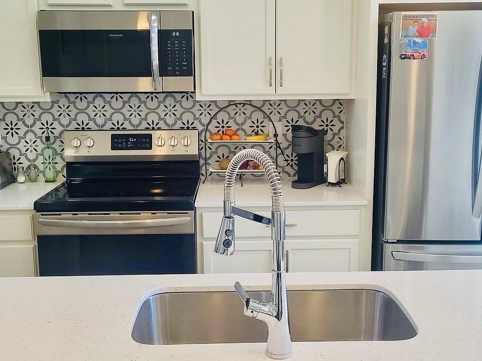 Stainless Steel appliances and white quartz counter tops