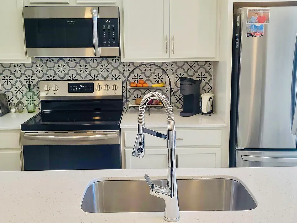 Stainless Steel appliances and white quartz counter tops