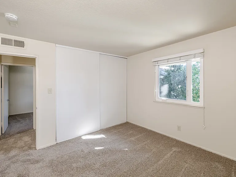 Bedroom D features a generous closet and a large window that fills the room with natural light.