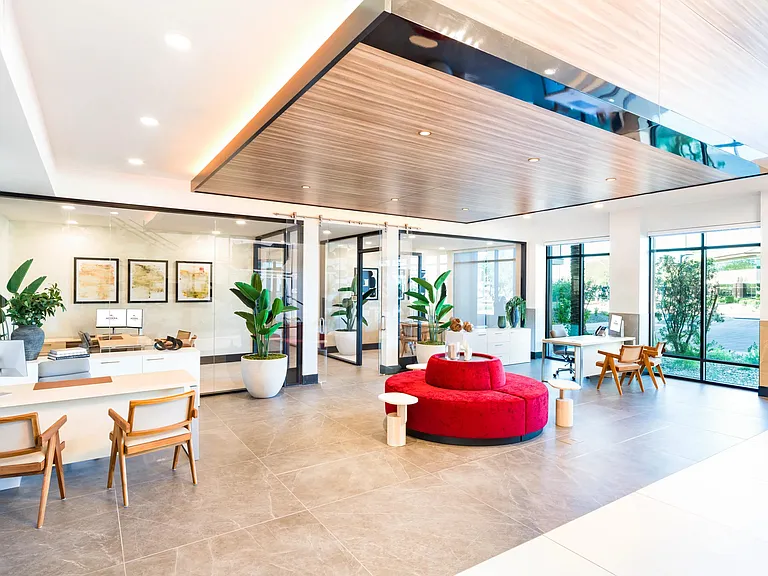 The bright, open leasing office sets a great first impression with sleek finishes, full-height windows, and comfortable seating while you select your new home.