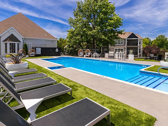 Enjoy a sunny day by the pool featuring comfortable lounge chairs, stylish seating, and a beautifully landscaped setting perfect for relaxation.