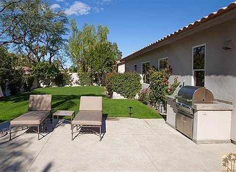 West side of this home features a large lawn, sunning area and barbecue island