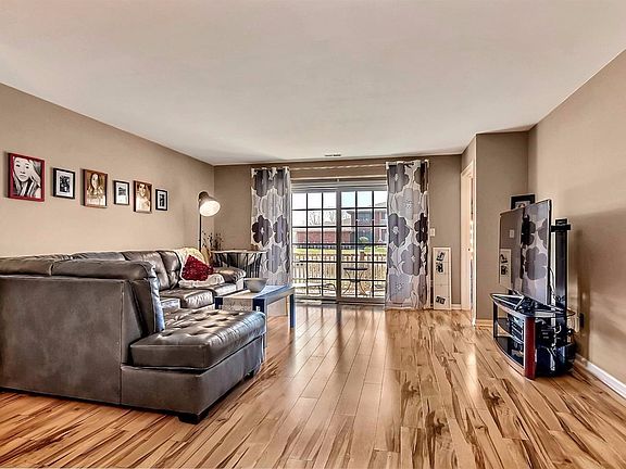 LARGE LIVING ROOM WITH NEWER LAMINATE FLOORING AND PATIO DOOR WITH POND VIEWS