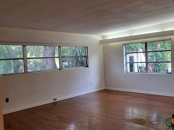 Large Living room with lots of windows and indirect lighting, and hardwood floors.