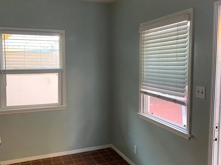 Front corner of living room with generous natural lighting. Freshly painted.