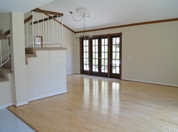 Bright Living and Dining room with elegant French doors ,Crown molding, high ceiling and wood floor.