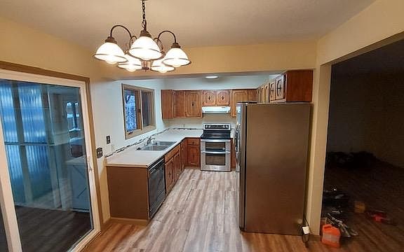 Sliding glass door to greenhouse & BBQ area outside, dishwasher, double oven with range, large stainless refrigerator with ice maker and dispenser.