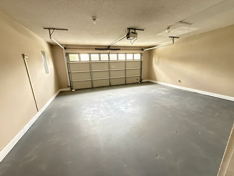 Expansive two-car garage featuring a freshly sealed and beautifully clean floor surface.