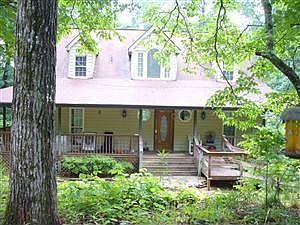 Wrap Around Porch On This Woodland Home