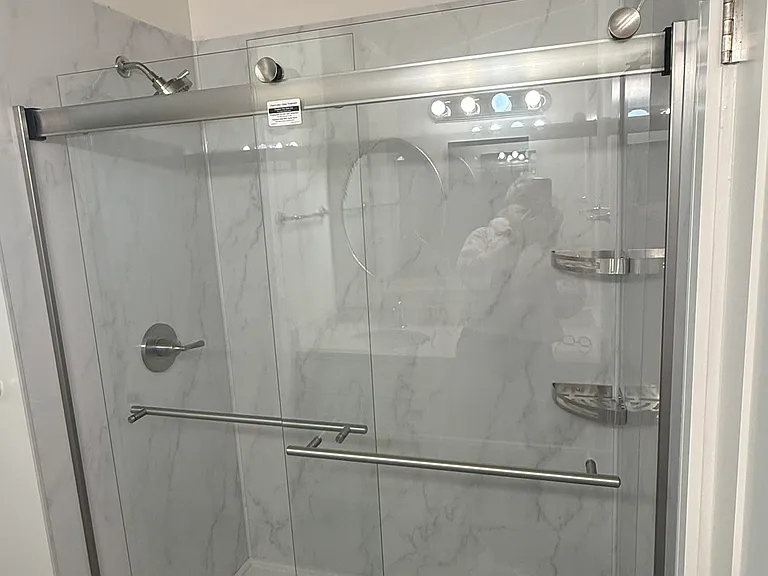 Remodeled shower with sliding glass door.