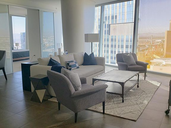 The living room features a stylish sofa that effortlessly transforms into a full-size, ultra-comfortable queen bed, perfect for accommodating guests.