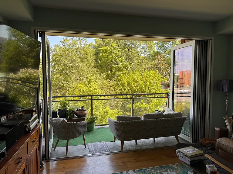 View onto deck with doors fully open into park area.