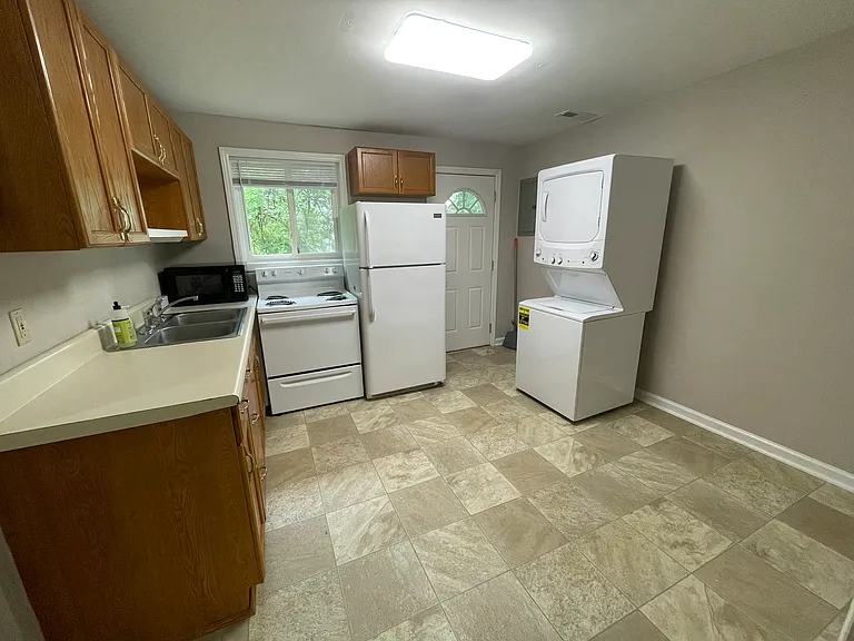 The kitchen includes oak cabinetry, stainless steel sink, stove, refrigerator, washer and dryer, and dining area.