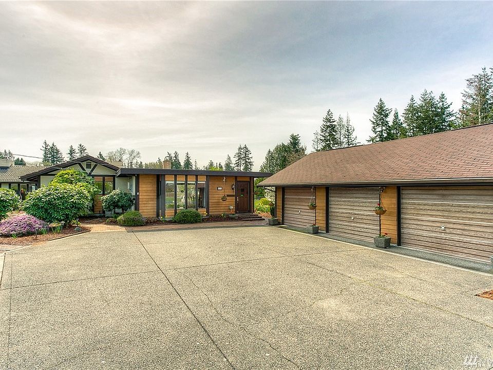 Meticulously maintained custom rambler with coordinating detached 3 car garage/shop.