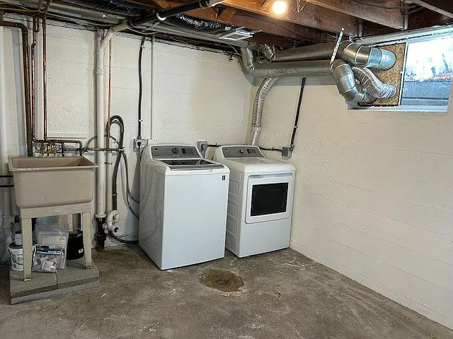 Full-size washer and dryer, utility sink in laundry/storage room.