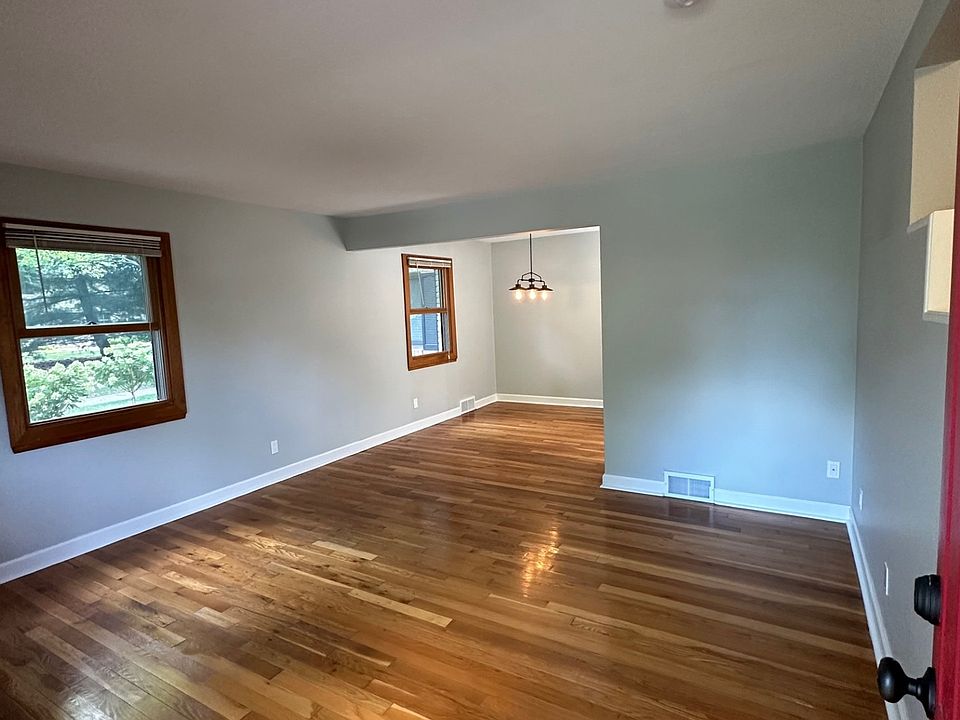 View of living room from the front door. Two windows facing an open courtyard and one facing the front yard