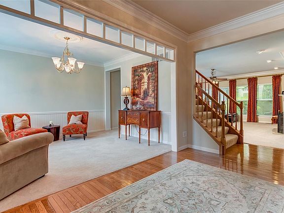 Large entrance foyer which opens to dining room and great room has beautiful wood floor, triple crown molding and open staircase to second floor