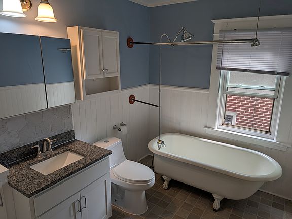 Newly renovated bathroom with granite countertop, new vanity, built in cabinet and new wall cabinet storage. Original clawfoot soaking tub has a shower attachment.