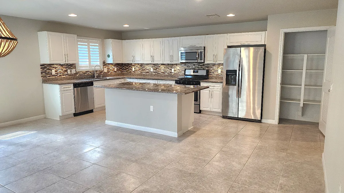 Open kitchen with stainless steel appliances, granite counters and undercabinet lighting. - 5713 Boros Dr