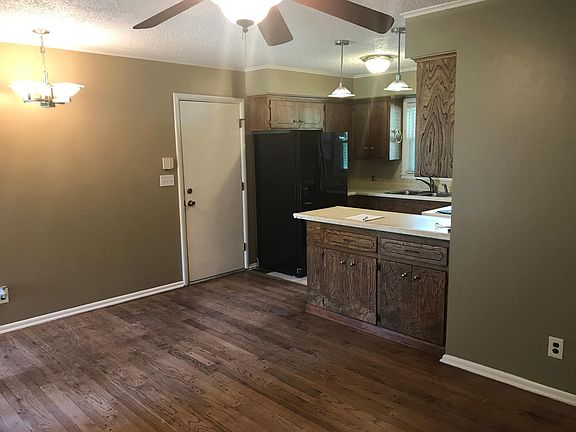 Hardwood floors in dining area. View of kitchen.