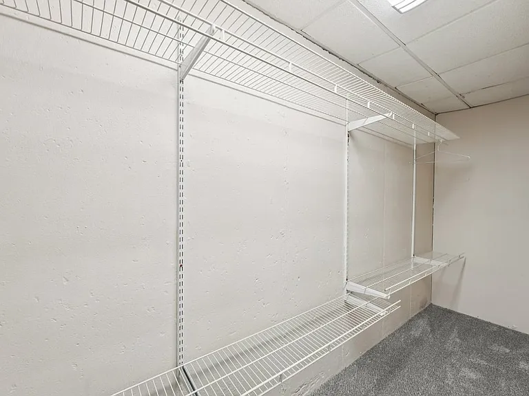 A generous storage closet with crisp wire shelving and soft carpeting, offering a practical place to keep life organized with quiet, tucked away charm.