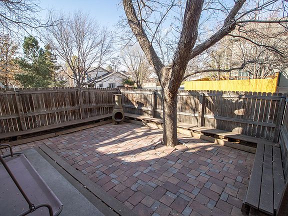 Brick patio with swing, built-in benches and chiminea. Tree has been removed.