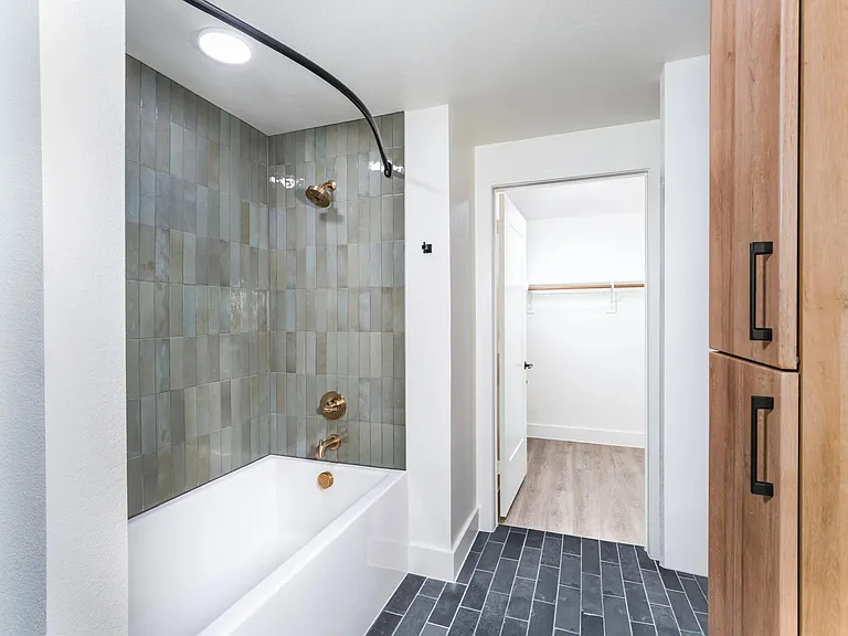 Unwind in a bathroom that feels like a retreat, complete with a soaking tub and elegant tile surrounds.
