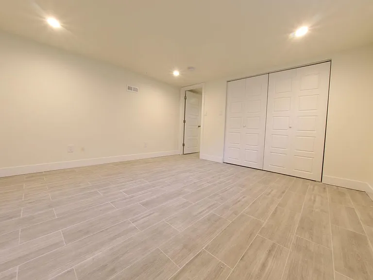 View 2 of Basement Master Bedroom with Closet doors closed.