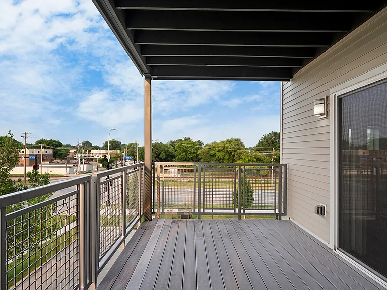 Modern apartment balcony with sleek railing overlooking a vibrant urban neighborhood, perfect for relaxing or entertaining. Modern apartment balcony with sleek railing overlooking a vibrant urban neighborhood, perfect for relaxing or entertaining.