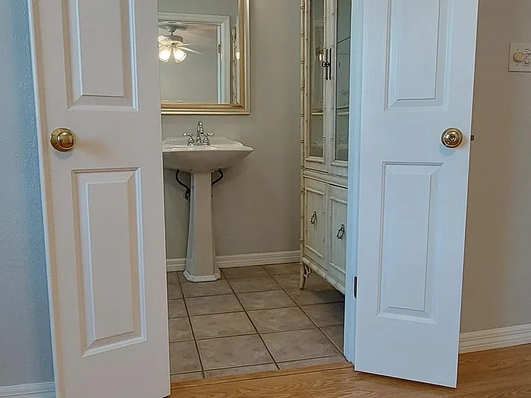 Bathroom with mini-French door and cabinet for storage.