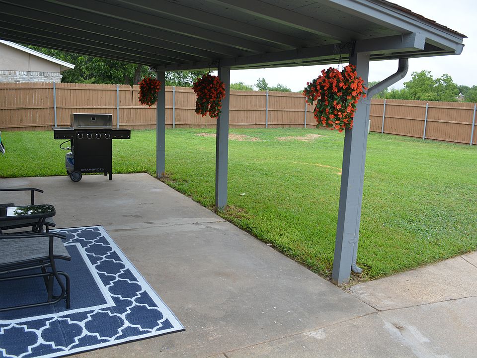 Covered patio area with outdoor furniture and a BBQ grill.