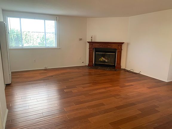 Living room with hardwood floor and wood burning fireplace