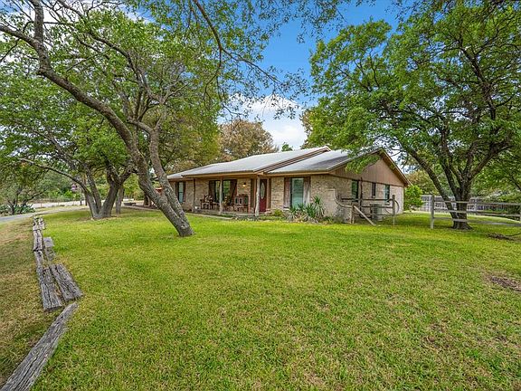 Massive trees frame this one of a kind farmhouse