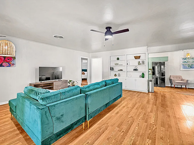 Bright living room with ample seating, Smart TV, and direct access to covered patio.
