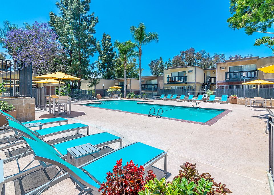 Outdoor swimming pool area with sundeck and lounge seating.