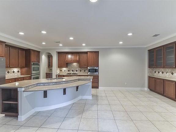 Chef's kitchen with double ovens, built-in fridge, breakfast bar, and butler's pantry with glass inserts, and plenty of cabinet and counter space. Breakfast Room offers access to the backyard.
