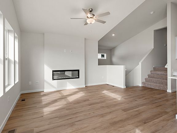 The family room is spacious and has a ceiling fan and fireplace.